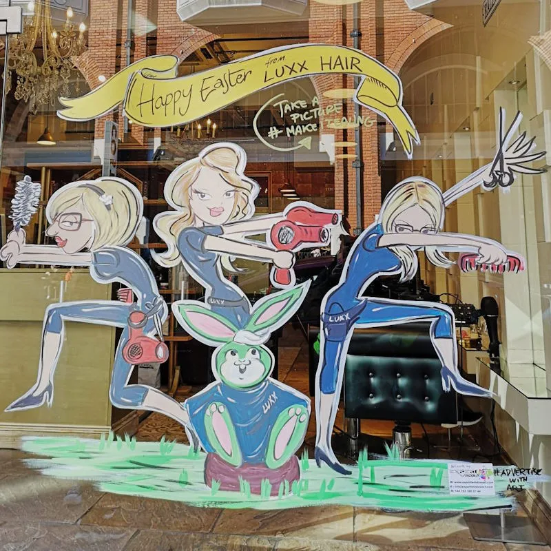 Bespoke hand painted window art of three hairdressers wishing their customers a Happy Easter